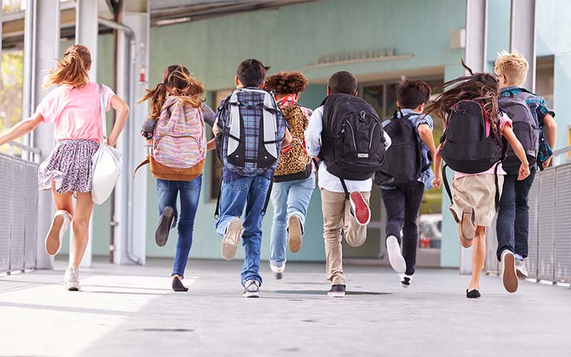 A man sitting in a car, smiling warmly.